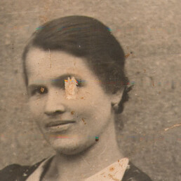 Damaged black and white portrait with stains and missing facial detail